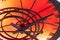 An abstract fragment of a decorative brass clockwork on a shiny red-orange background.