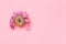 Abstract funny face of woman from donut with eyes and hair from centimeter tape on pink background. Diet or unhealthy food concept