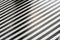 Abstract geometric pattern of regular alternating black and white stripes on the floor.