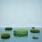 Abstract green cylindrical podium on water surface 3D render illustration