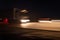 Abstract image with blurry car fragments on a speedway.The cars moves at fast speed at the night. Blurred lights with car on high