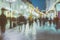 Abstract image of unrecognizable silhouettes of people walking in city street in evening, nightlife. Urban modern