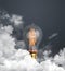 abstract light bulb glowing on dark grey background with clouds