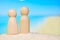 Abstract little men in the sand on a blurred beach background. Family vacation concept