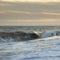 Abstract long exposure landscape image of waves crashing onto groynes on beach during sunset