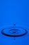 Abstract Macro Shot of The Only Blue Water Droplet Over Tranquil Water Surface