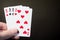 Abstract: man hand holding playing card four eight isolated on black background with copyspace poker set four eight