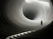 Abstract minimalistic interior black and white 3D tunnel and silhouette of a woman in it. AI