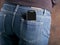 Abstract mobile phone in the back pocket of jeans