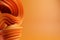 Abstract modern dynamic orange flowing curve swirl or twirl spiral shape lines on orange background with copy space