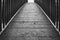 Abstract, monochrome view of a timber built footbridge seen in a forest clearing.