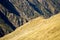 Abstract mountain landscape background with a grass ridge cutting diagonally across rock walls in the back