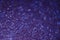 Abstract New Year violet bokeh background with shining defocus sparkles. Blurred glitters shimmering dust macro close up