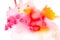 Abstract painting with bright red, pink and orange watercolour paint blots