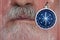 Abstract photo of part of face of man with compass on a wooden background