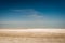 An abstract photograph of the Etosha Pan, showing the arid earth, the dry pan and a deep blue sky