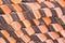 Abstract piles and packs of a new clay ceramic tiles to cover the roof of a Buddhist temple. Stack of new orange roof tiles in the