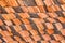 Abstract piles and packs of a new clay ceramic tiles to cover the roof of a Buddhist temple. Stack of new orange roof tiles in the