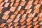 Abstract piles and packs of a new clay ceramic tiles to cover the roof of a Buddhist temple. Stack of new orange roof tiles in the