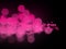Abstract pink bokeh circles on dark background