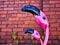 Abstract pink flamingos in front of brick wall