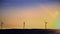 Abstract power windmills on the horizon and a beautiful, golden sunset landscape. Clean and ecological energy generated