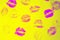 Abstract purple lipstick kisses on yellow art background