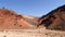 Abstract red mountains rocks and dry river in the Ounila Valley, High Atlas Mountains, Morocco.