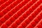 Abstract red silicone pyramids array close-up background