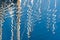 Abstract Reflection of colorful sailboats masts on a rippled water surface