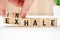 Abstract selection of inhale exhale phrases on wooden blocks