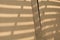 Abstract shadow pattern on surface of 2 corrugated brown cardboard sheets that is leaning against the wall