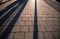 Abstract shadows of people walking in a street of the city. The sidewalk is sprinkled with granite crumb