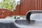 Abstract, shallow focus image of a trio of household bins showing the green bin handle in focus.