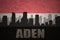 abstract silhouette of the city with text Aden at the vintage yemen flag