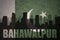 Abstract silhouette of the city with text Bahawalpur at the vintage pakistan flag