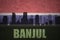 Abstract silhouette of the city with text Banjul at the vintage gambia flag