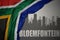 Abstract silhouette of the city with text Bloemfontein near waving colorful national flag of south africa on a gray background