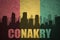 Abstract silhouette of the city with text Conakry at the vintage guinea flag