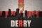 Abstract silhouette of the city with text Derry at the vintage northern ireland flag