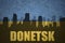 Abstract silhouette of the city with text Donetsk at the vintage ukrainian flag