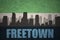 Abstract silhouette of the city with text Freetown at the vintage sierra leone flag