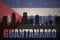 Abstract silhouette of the city with text Guantanamo at the vintage cuban flag