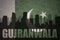 Abstract silhouette of the city with text Gujranwala at the vintage pakistan flag