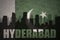 Abstract silhouette of the city with text Hyderabad at the vintage pakistan flag