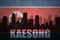 Abstract silhouette of the city with text Kaesong at the vintage north korea flag