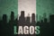 Abstract silhouette of the city with text Lagos at the vintage nigerian flag