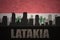 Abstract silhouette of the city with text Latakia at the vintage syrian flag