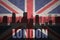 Abstract silhouette of the city with text London at the vintage british flag