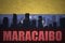 Abstract silhouette of the city with text Maracaibo at the vintage venezuelan flag